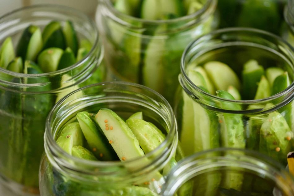 Cucumber background with many cucumbers in glass jars