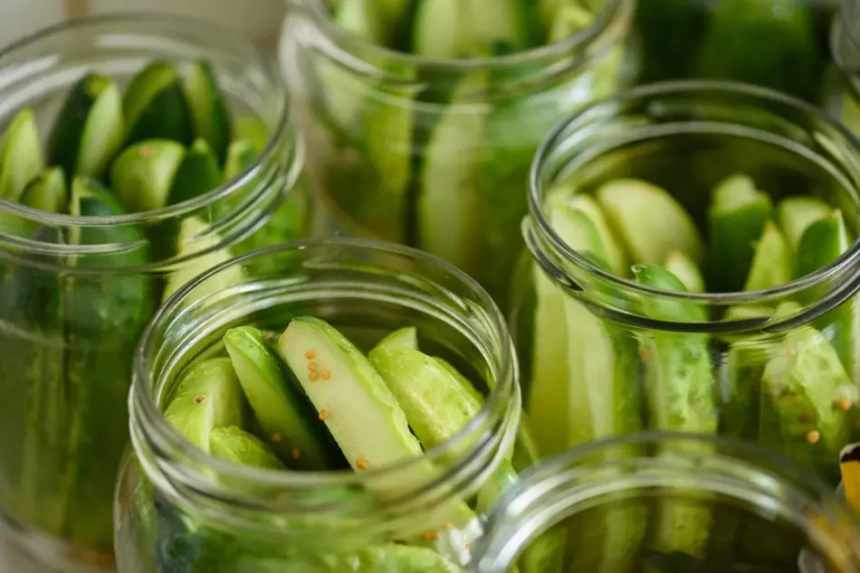 A close up of cucumbers in jars